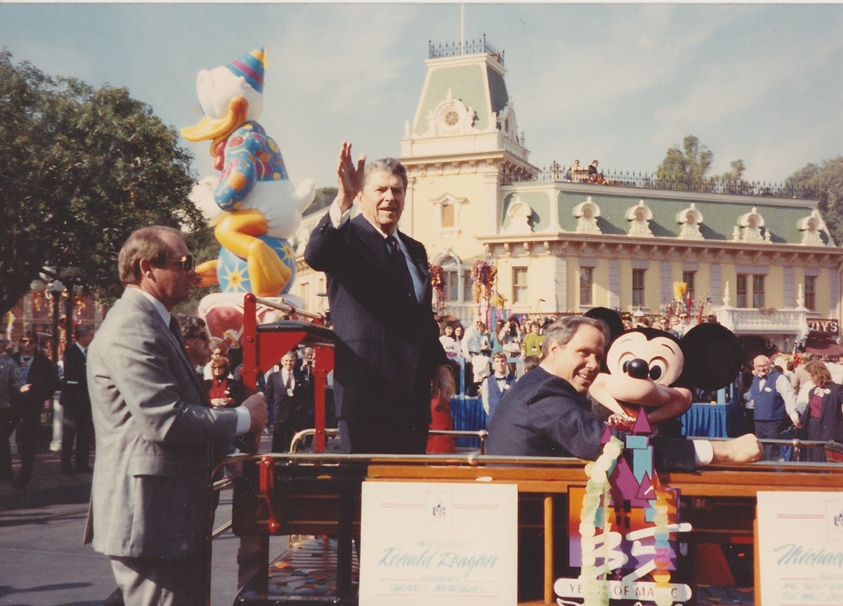 Ronald Reagan, Michael Eisner and Mickey Mouse travel down the parade route.