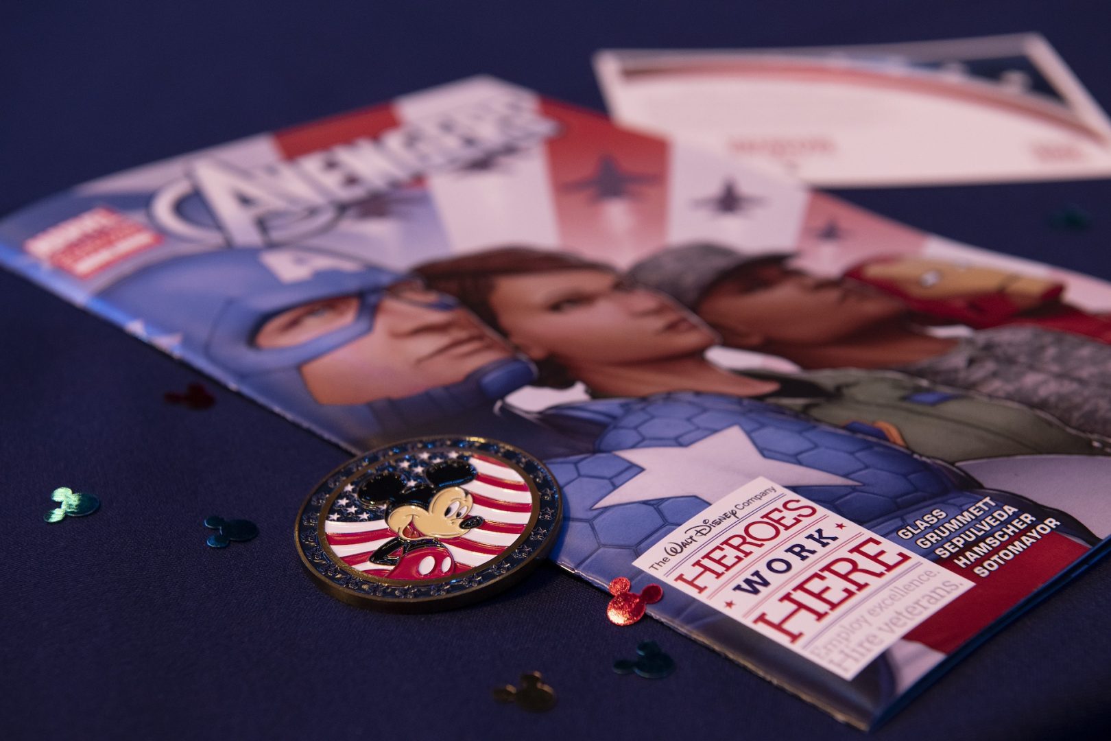 A button with Mickey Mouse and a magazine with text: The Walt Disney Company, Heroes Work Here