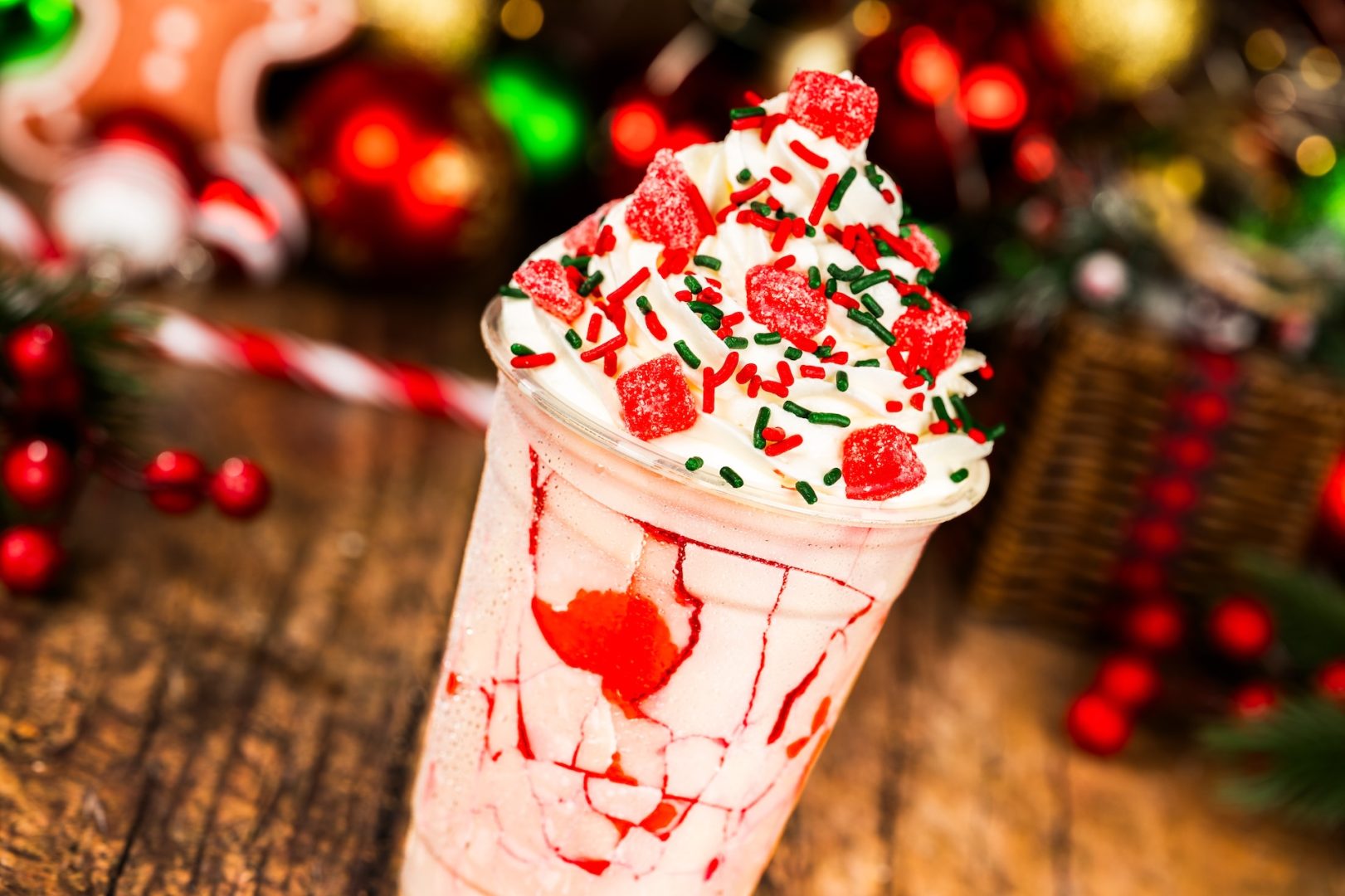 Cherry-White Chocolate Slushy: Fanta Cherry served with a crackable white chocolate-coated cup with whipped cream, cherry gummy candy, and festive sprinkles