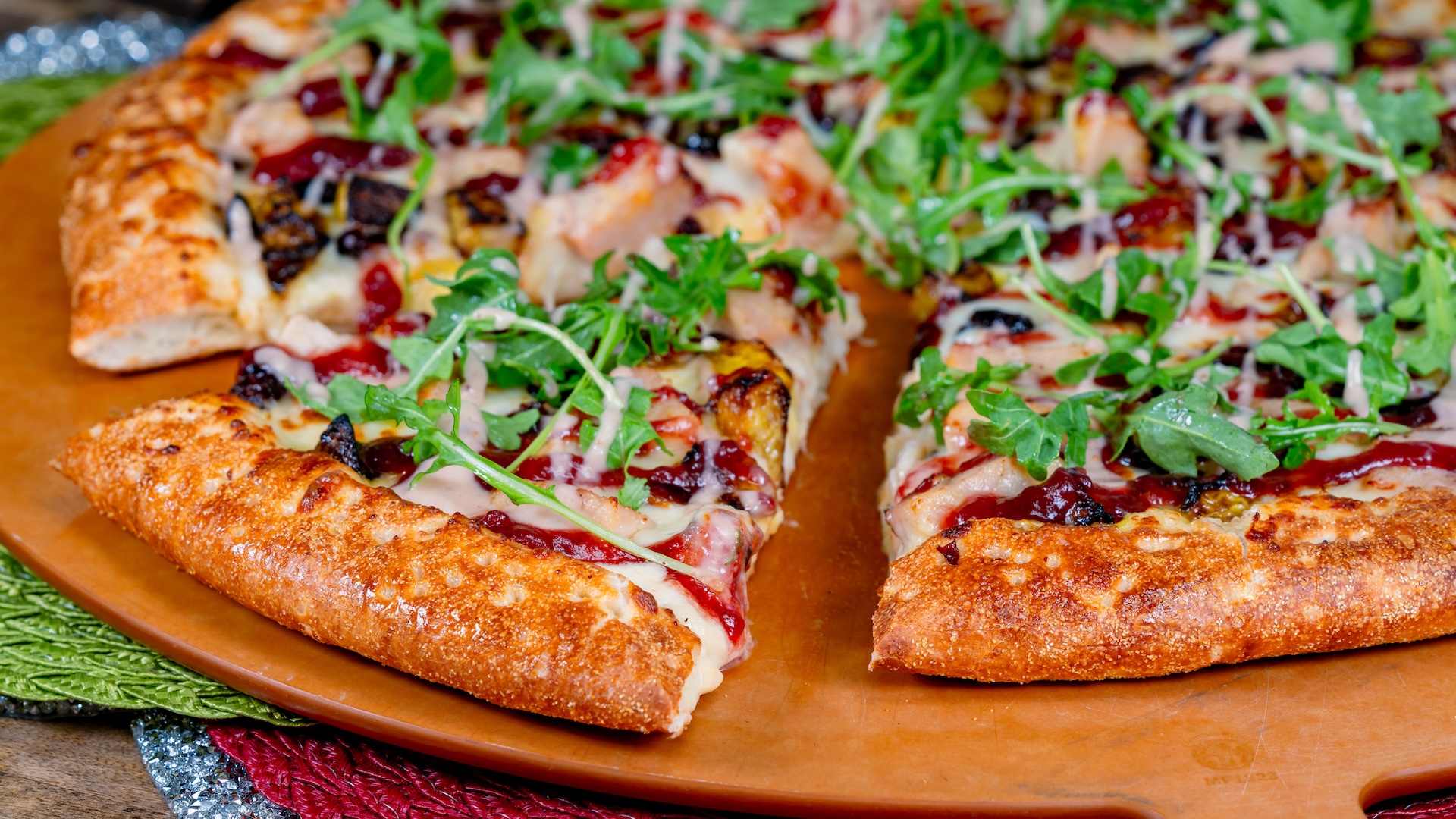 Holiday Pizza: Roasted turkey with roasted butternut squash, cranberries, arugula, fig jam, and cranberry sauce (Available by the slice or as a whole pie)
