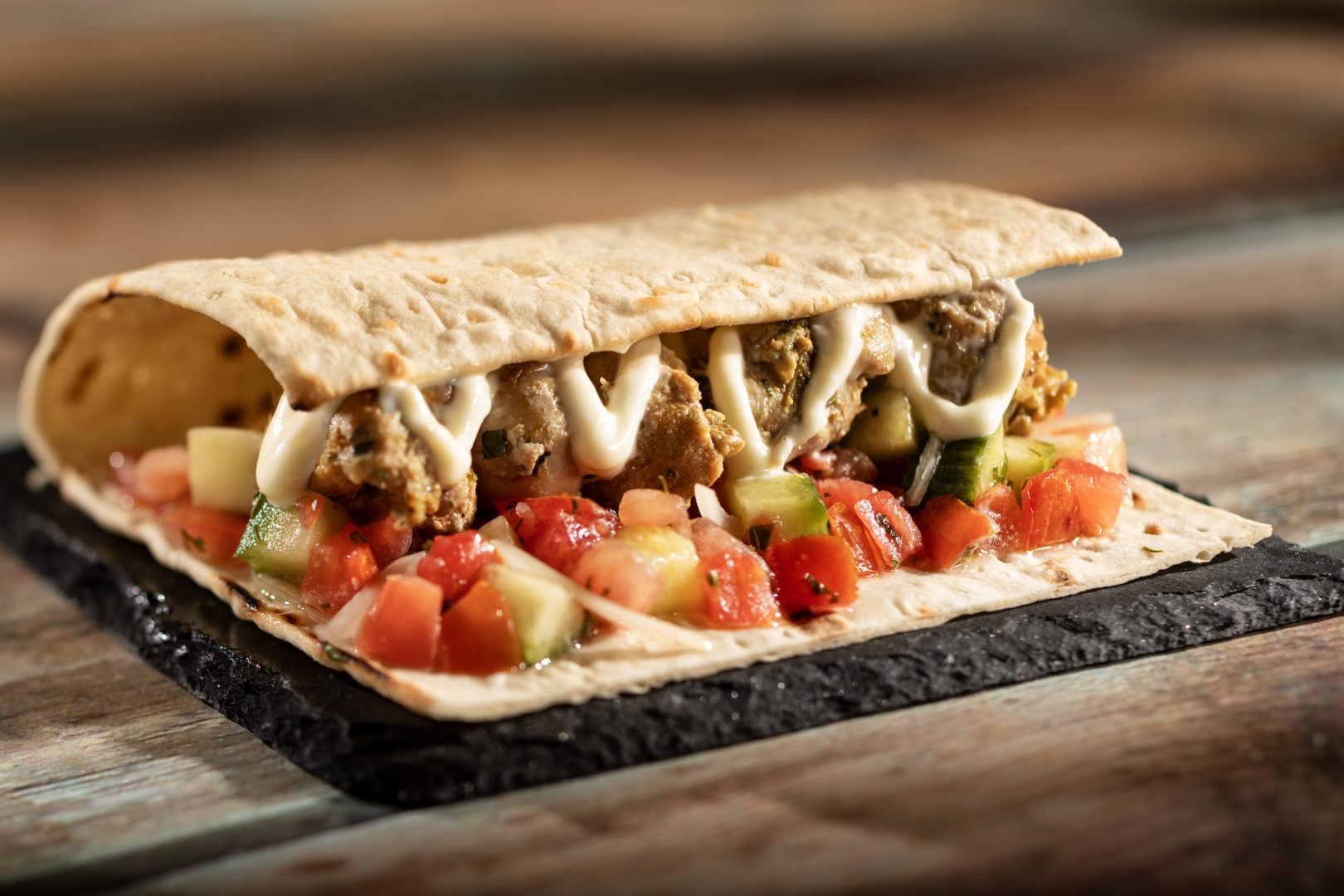 Moroccan Wrap with tomato-cucumber relish and garlic sauce served on warm Moroccan flatbread