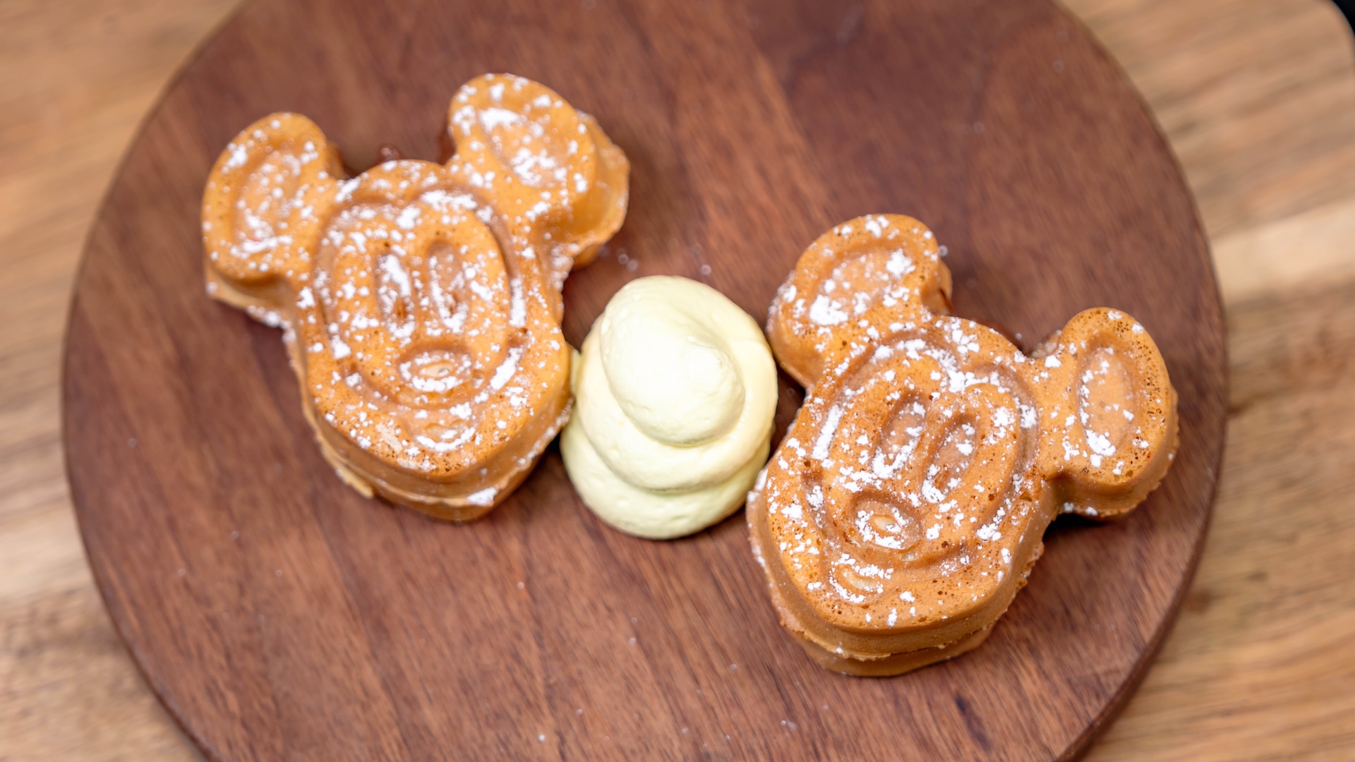 Mickey-shaped Banana-Hazelnut Waffles: Mickey-shaped waffles with chocolate-hazelnut filling topped with banana whipped topping and powdered sugar (New)