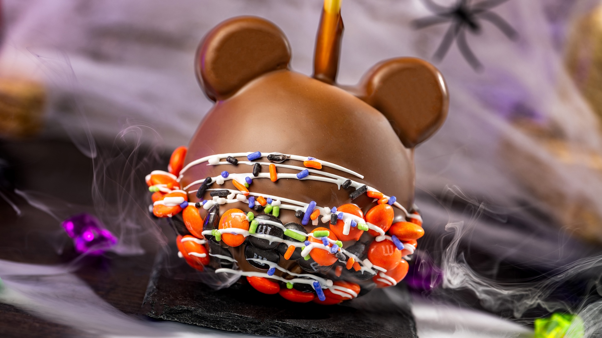 Mickey Halloween Caramel Apple with M&M’S Milk Chocolate Candies: Granny Smith apple with marshmallow ears dipped in caramel and milk chocolatey coating with M&M