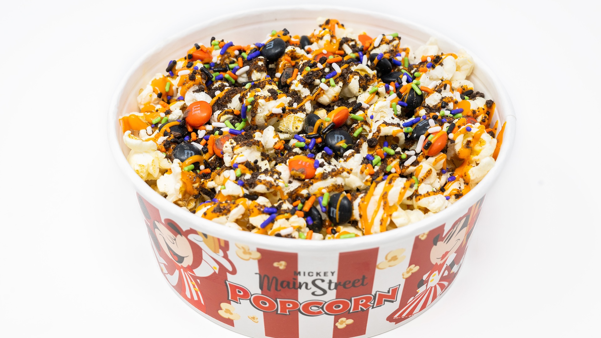 Halloween Treat Popcorn Mix with M&M’S Milk Chocolate Candies: Buttered popcorn with M&M’S milk chocolate candies Halloween blend, crushed chocolate cookies, Halloween sprinkles, and orange chocolatey drizzle  
